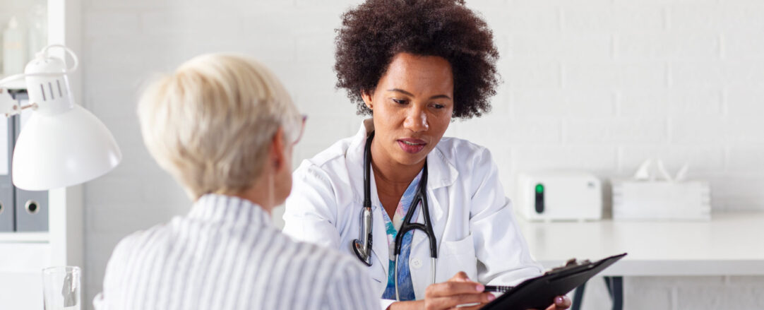 Mature woman with her doctor in ambulance talking about healthcare